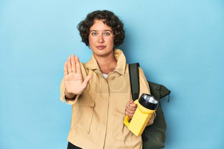 Téléchargez les photos : Voyageur femme avec appareil photo vintage et lampe de poche debout avec la main tendue montrant stop signe, vous empêchant. - en image libre de droit