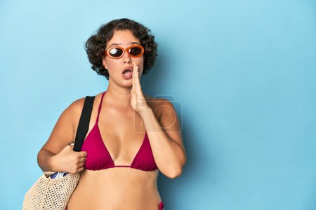 Téléchargez les photos : Jeune femme en bikini avec sac de plage dit une nouvelle secrète de freinage chaud et regarder de côté - en image libre de droit