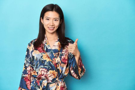 Photo for Elegant young Asian woman in kimono, studio shot smiling and raising thumb up - Royalty Free Image