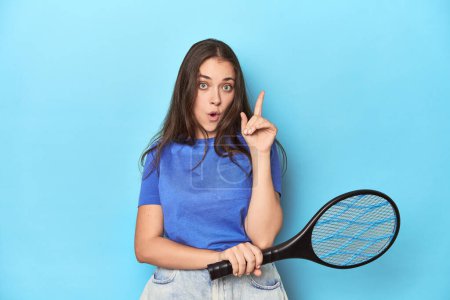 Photo for Woman with an electric bug zapper on a blue background having some great idea, concept of creativity. - Royalty Free Image