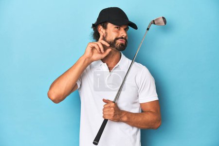 Foto de Golfista de pelo largo con club y sombrero tratando de escuchar un chisme. - Imagen libre de derechos