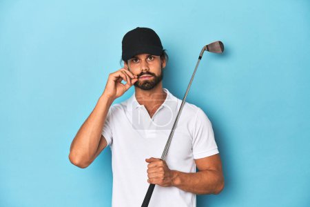 Photo for Long-haired golfer with club and hat with fingers on lips keeping a secret. - Royalty Free Image