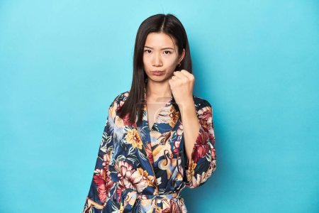 Téléchargez les photos : Élégante jeune femme asiatique en kimono, prise de vue en studio montrant le poing à la caméra, expression faciale agressive. - en image libre de droit