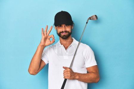 Foto de Golfista de pelo largo con club y sombrero alegre y confiado mostrando buen gesto. - Imagen libre de derechos