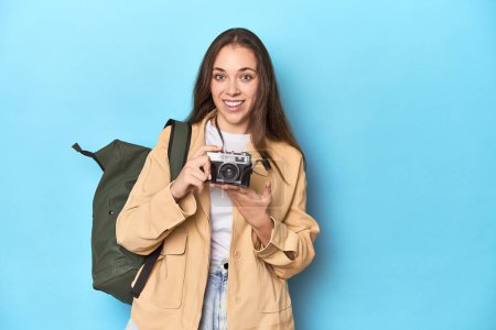 Foto de Mujer viajera tomando fotos con una cámara vintage en azul. - Imagen libre de derechos