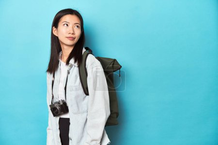 Téléchargez les photos : Jeune voyageur asiatique prêt à capturer des aventures, rêvant d'atteindre des objectifs et des buts - en image libre de droit