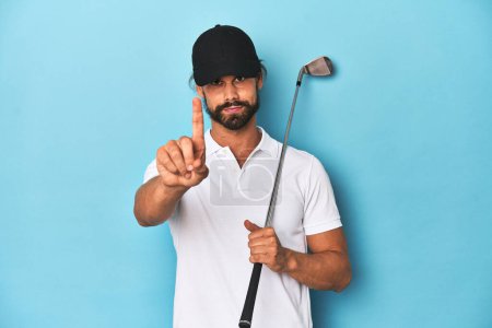 Téléchargez les photos : Golfeur aux cheveux longs avec club et chapeau montrant numéro un avec doigt. - en image libre de droit