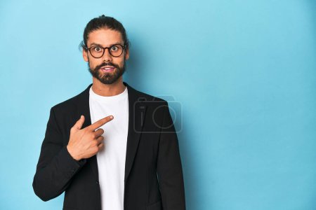 Téléchargez les photos : Homme d'affaires en costume avec lunettes et barbe pointant vers le côté - en image libre de droit