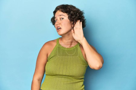 Foto de Joven mujer caucásica con el pelo corto tratando de escuchar un chisme. - Imagen libre de derechos
