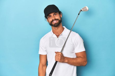 Foto de Golfista de pelo largo con club y sombrero feliz, sonriente y alegre. - Imagen libre de derechos