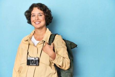 Foto de Joven viajero mujer caucásica con cámara vintage y mochila, toma de estudio. - Imagen libre de derechos