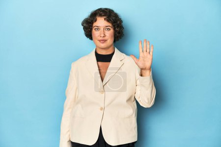 Téléchargez les photos : Jeune femme en élégant blazer blanc souriant gai montrant numéro cinq avec les doigts. - en image libre de droit