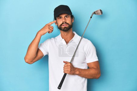Foto de Golfista de pelo largo con club y sombrero mostrando un gesto de decepción con el dedo índice. - Imagen libre de derechos