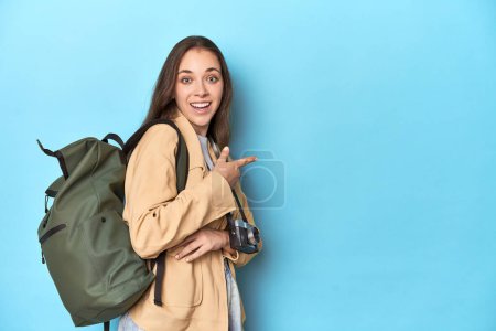 Photo for Traveling woman with vintage camera and backpack on blue. - Royalty Free Image