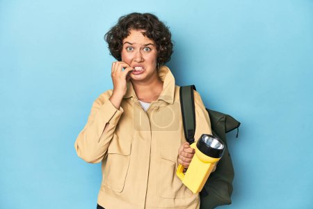 Téléchargez les photos : Voyageur femme avec appareil photo vintage et lampe de poche mordre les ongles, nerveux et très anxieux. - en image libre de droit