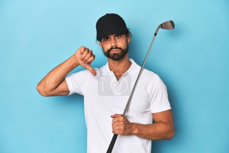 Photo for Long-haired golfer with club and hat showing a dislike gesture, thumbs down. Disagreement concept. - Royalty Free Image