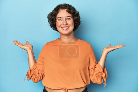 Téléchargez les photos : Jeune femme caucasienne aux cheveux courts fait échelle avec les bras, se sent heureux et confiant. - en image libre de droit
