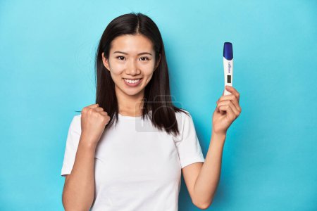 Téléchargez les photos : Femme asiatique avec test de grossesse, célébrant sa grossesse. - en image libre de droit