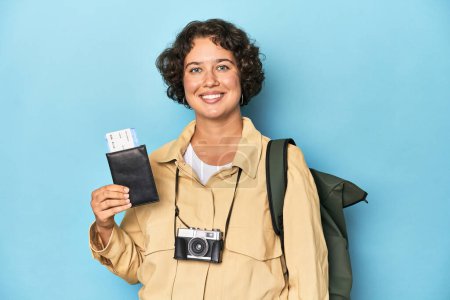 Photo for Young traveler woman with backpack and airplane ticket, studio shot. - Royalty Free Image