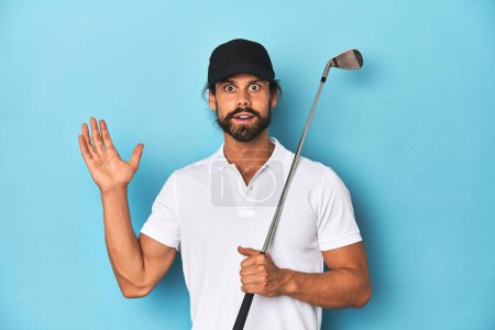 Foto de Golfista de pelo largo con club y sombrero sorprendido y sorprendido. - Imagen libre de derechos