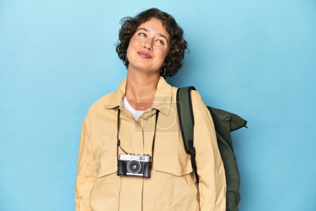 Téléchargez les photos : Jeune voyageuse avec caméra vintage rêvant d'atteindre des objectifs et des buts - en image libre de droit