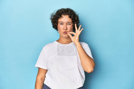 Téléchargez les photos : Jeune femme caucasienne aux cheveux courts avec les doigts sur les lèvres gardant un secret. - en image libre de droit