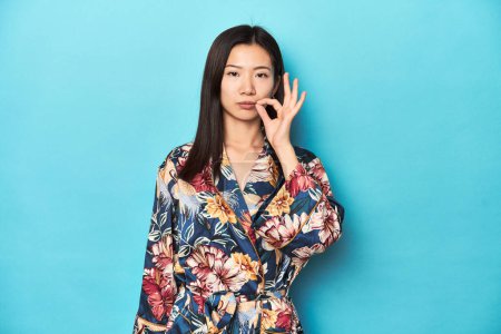 Téléchargez les photos : Élégante jeune femme asiatique en kimono, studio tourné avec les doigts sur les lèvres gardant un secret. - en image libre de droit