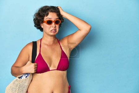 Téléchargez les photos : Jeune femme en bikini avec sac de plage étant choquée, elle s'est souvenue d'une réunion importante. - en image libre de droit
