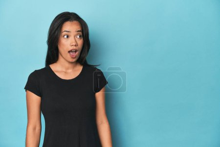 Foto de Filipina joven mujer en azul estudio siendo sorprendido por algo que ella ha visto. - Imagen libre de derechos