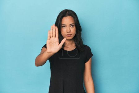 Téléchargez les photos : Philippine jeune femme sur studio bleu debout avec la main tendue montrant stop signe, vous empêchant. - en image libre de droit