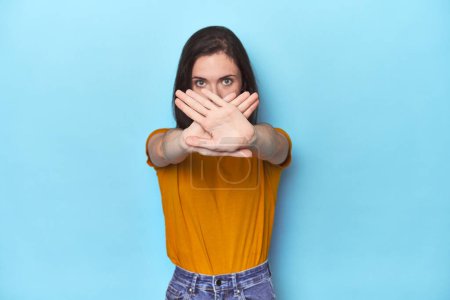 Photo for Young caucasian woman on blue backdrop doing a denial gesture - Royalty Free Image