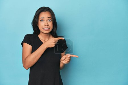 Téléchargez les photos : Philippine jeune femme sur bleu studio choqué pointant avec index à un espace de copie. - en image libre de droit