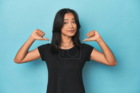 Téléchargez les photos : Philippine jeune femme sur studio bleu se sent fier et confiant, exemple à suivre. - en image libre de droit