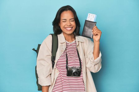 Foto de Filipina viajero mostrando billete de avión con cámara y mochila en azul - Imagen libre de derechos