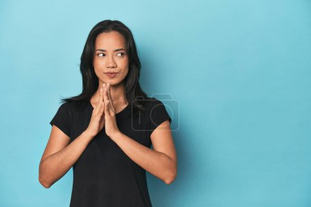Photo for Filipina young woman on blue studio making up plan in mind, setting up an idea. - Royalty Free Image