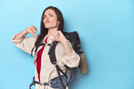 Téléchargez les photos : Femme aventureuse avec sac à dos sur bleu se sent fière et confiante, exemple à suivre. - en image libre de droit