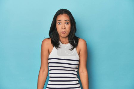 Téléchargez les photos : Philippine jeune femme sur bleu studio hausser les épaules et les yeux ouverts confus. - en image libre de droit