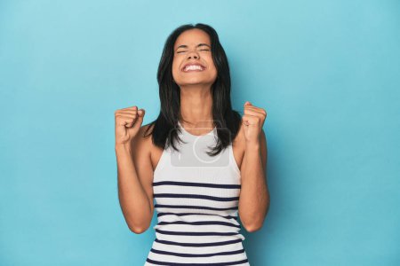Photo for Filipina young woman on blue studio celebrating a victory, passion and enthusiasm, happy expression. - Royalty Free Image