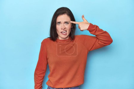 Photo for Young caucasian woman on blue backdrop showing a disappointment gesture with forefinger. - Royalty Free Image