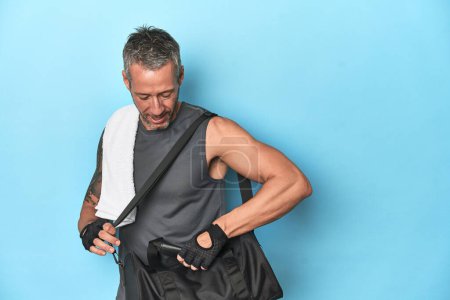 Photo for Athlete with gym backpack on blue studio backdrop - Royalty Free Image