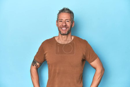 Photo for Middle-aged caucasian man on blue backdrop confident keeping hands on hips. - Royalty Free Image