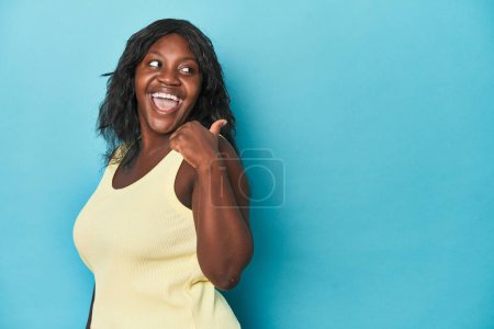 Téléchargez les photos : Jeune femme afro-américaine courbée pointe avec le pouce loin, riant et insouciant. - en image libre de droit
