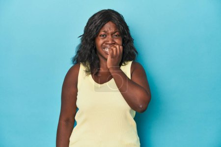 Photo for Young african american curvy woman biting fingernails, nervous and very anxious. - Royalty Free Image