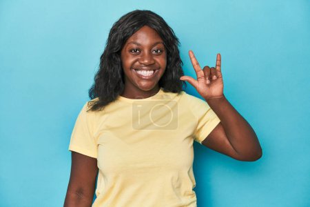 Photo for Young african american curvy woman showing a horns gesture as a revolution concept. - Royalty Free Image