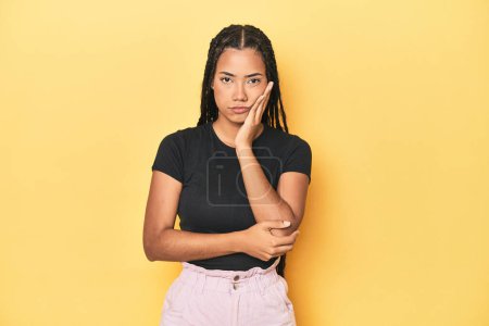 Photo for Young Indonesian woman on yellow studio backdrop who is bored, fatigued and need a relax day. - Royalty Free Image