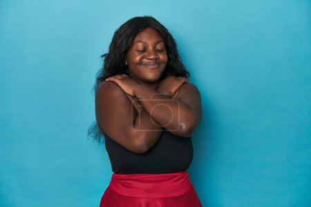 Photo for Young african american curvy woman hugs, smiling carefree and happy. - Royalty Free Image
