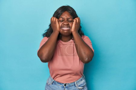 Téléchargez les photos : Jeune femme courbée afro-américaine pleure, malheureuse avec quelque chose, l'agonie et la confusion concept. - en image libre de droit