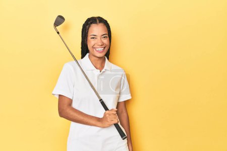 Photo for Indonesian female golfer on yellow studio background - Royalty Free Image
