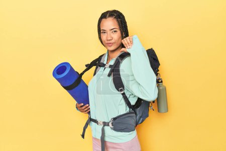 Téléchargez les photos : Femme indonésienne prête pour le voyage en montagne sur jaune se sent fière et confiante, exemple à suivre. - en image libre de droit
