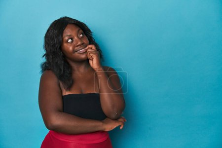 Photo for Young african american curvy woman relaxed thinking about something looking at a copy space. - Royalty Free Image